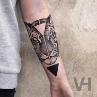 Symmetrical black ink forearm tattoo of tiger head with triangles by Valentin Hirsch