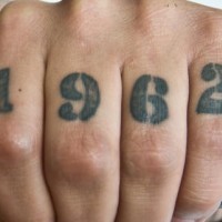 Tatuaje en los nudillos, fecha, cifras gruesos