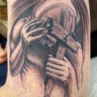 Ángel caído con cruz en la mano tatauje en tinta negra