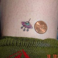 Small flying saucer coloured tattoo