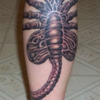 Facehugger reale tatuato sulla gamba