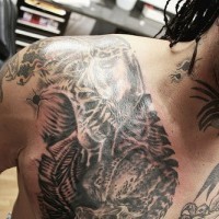 Le tatouage avec une bataille de xenomorph et  prédateur sur la poitrine