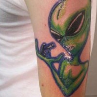 Le tatouage d'un vert extra-terrestre regardant sur toi