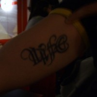 Le tatouage d'ambigramme la vie sur le bras