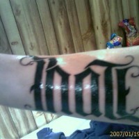 Tatuaje en el brazo Ambigrama negro