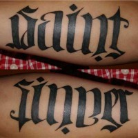Le tatouage d'ambigramme des mots le saint et le pécheur