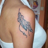 el tatuaje de un talisman con plumas hecho en el hombro