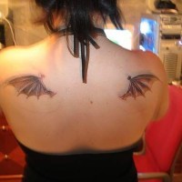 Pequeño tatuaje las alas del murciélago en los omoplatos
