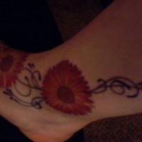 Tattoo von breiter roter Blume  in der Knöchelgegend