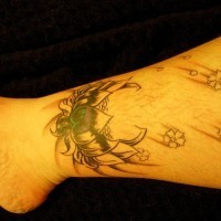 Cœur décoré avec le tatouage sur la cheville de fleurs tombantes