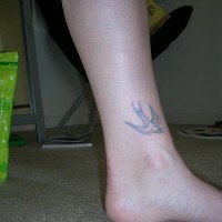 Tattoo von fliegender Schwalbe in der Knöchelgegend