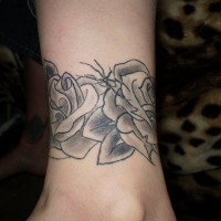 Tattoo von schwarzen umfassenden Rosen in der Knöchelgegend