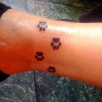 Tattoo von Hundespuren in der Knöchelgegend