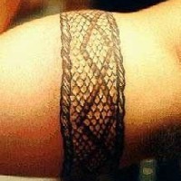 Le tatouage bracelet avec la peau d'un serpent sur le bras