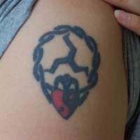 Coeur avec un sygne dans le chaîne le tatouage sur le bras