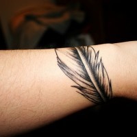 Uncolored feather arm tattoo