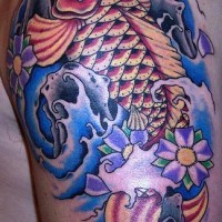 Fish in waves arm tattoo