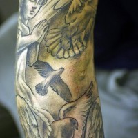 Angel and pigeons arm tattoo