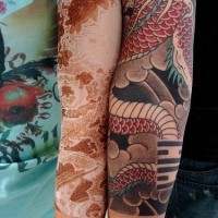 Red designed  tail arm tattoo