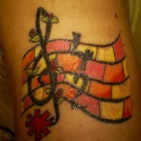 Tattoo mit Violinschlüssel und Notenlinien am Arm