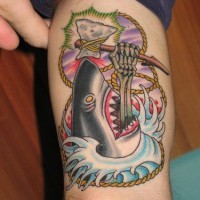 Skull in shark's mouth arm tattoo
