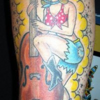 Fille avec le tatouage de guitare sur le bras