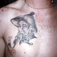 Tatuaje fumando en pipa de un viejo hombre asiático.