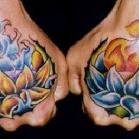 Zwei Lotus-Tattoos an Fingergliedern in Farbe