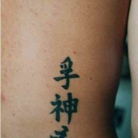 Tatuaje en la espalda de jeroglíficos asiáticos.