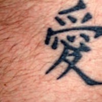 Le tatouage d'hiéroglyphes asiatiques sur certain partie de corps chevelue