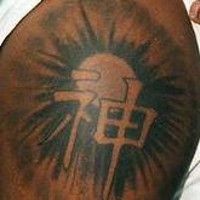 Scrittura asiatica con il sole sul fondo tatuati sul deltoide