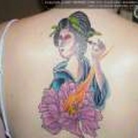 Tatuaje en la espalda de una geisha con flores.