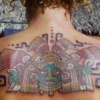 el tatuaje de un idolo azteca con una traceria alrededor hecho en colores en la espalda