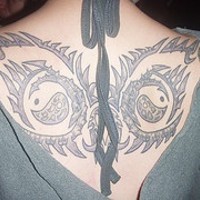 Tatuaje en la espalda de símbolos asiáticos.