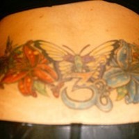 Tatuaje coloreado de una mariposa con flores.