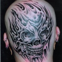 Le crâne noir avec les denta enflammé tatouage sur la tête en noir