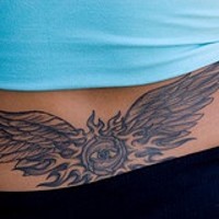Tatuaje en la cola de la base de un ojo con alas.