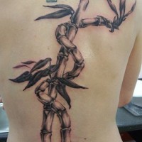 Tattoo mit Pflanze um Kreuz am oberen Rücken