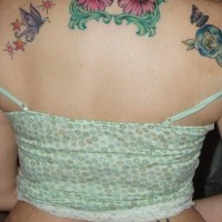 Le tatouage de haut du dos avec des fleurs et des papillons