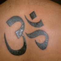 Black tattoo with sign hieroglyph on upper back