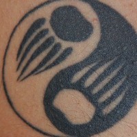 Le symbole d'yin yang avec un tatouage d'empreintes d'ours