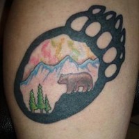 Tatuaje huella de oso con paisaje dentro