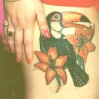 Le tatouage de cacatoès coloré dans les fleurs sur la hanche