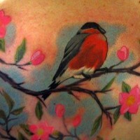 Tatuaggio colorato l'uccello sul ramoscello fiorito