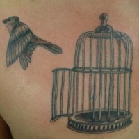 Bird flying out of bird cage tattoo