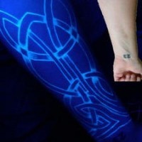 Celtic tracery uv ink arm tattoo