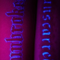 Glowing text uv ink tattoo with word Unbroken