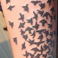 Black work bird flight tattoo