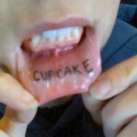 Bottom inner lip tattoo, cupcake, black word