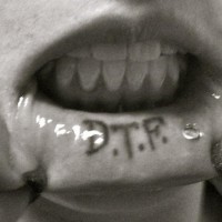 Bottom lip tattoo, dtf with dots, big, black letters